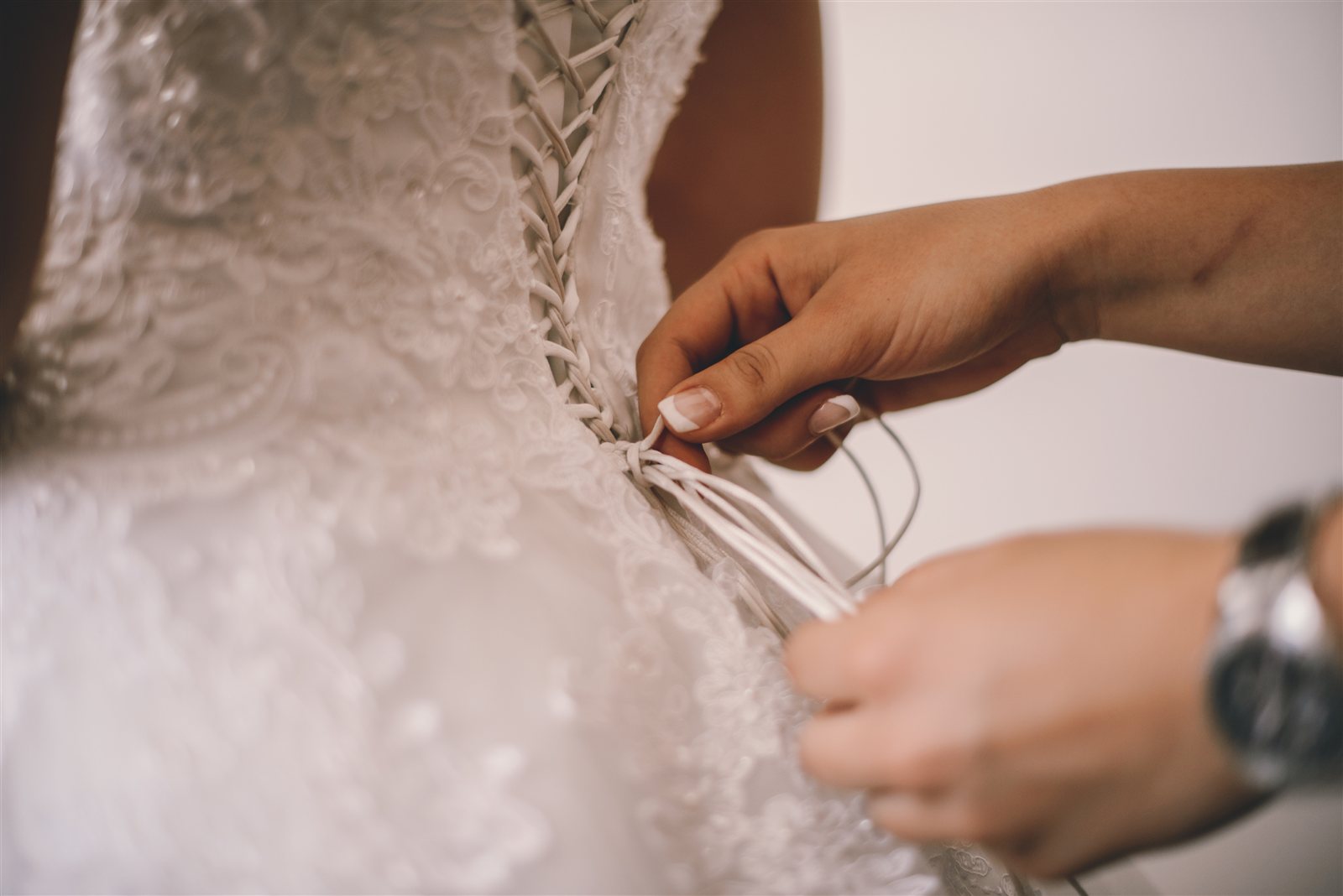 Braut beim Schnüren des Hochzeitskleids - entspannt in Form für den großen Tag